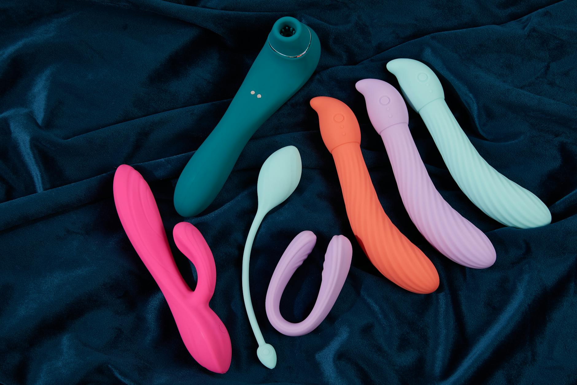 Yellow silicone vibrator surrounded by fresh lemons on bright background