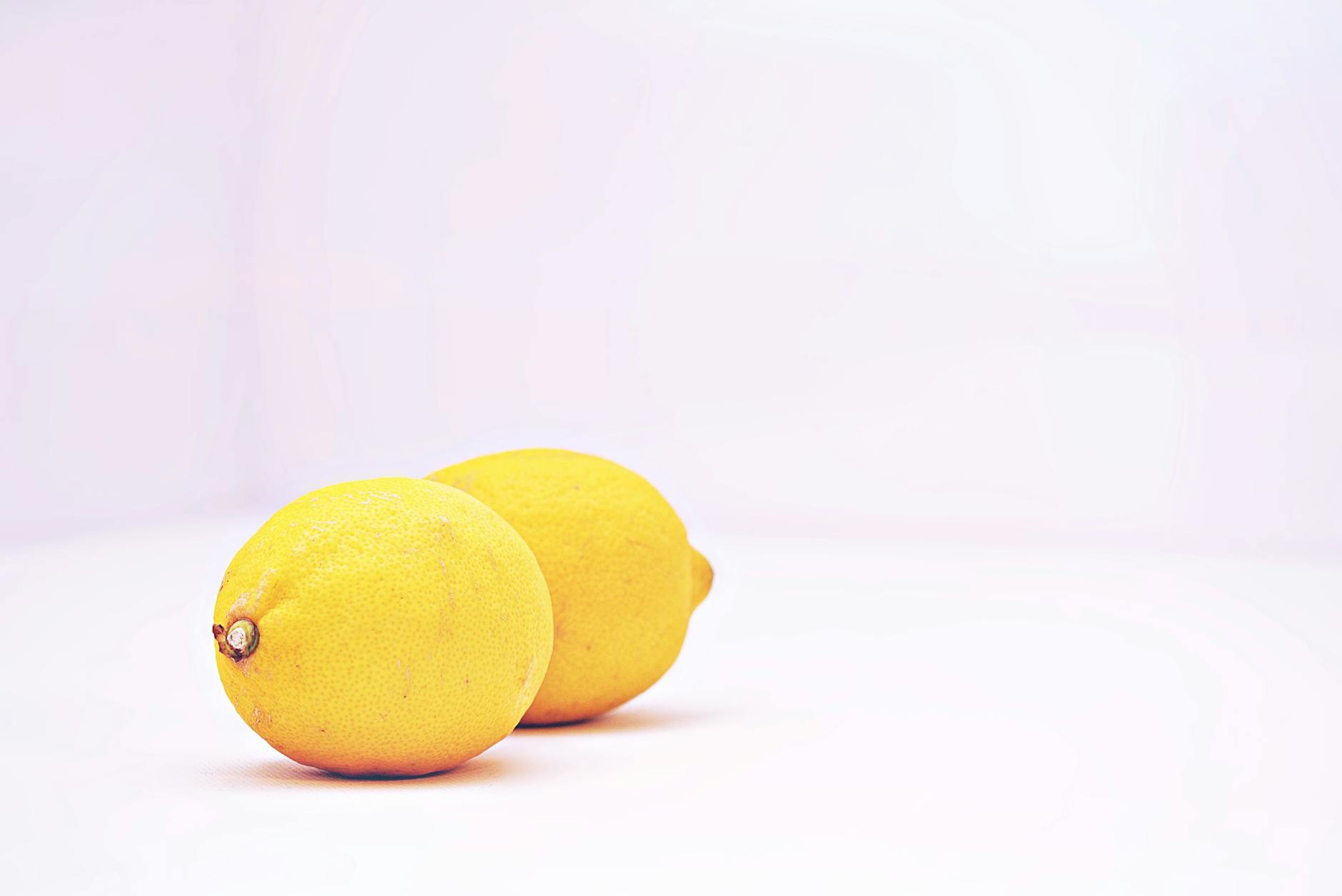 Fresh lemons on a pastel background, representing renewal and vitality after 40