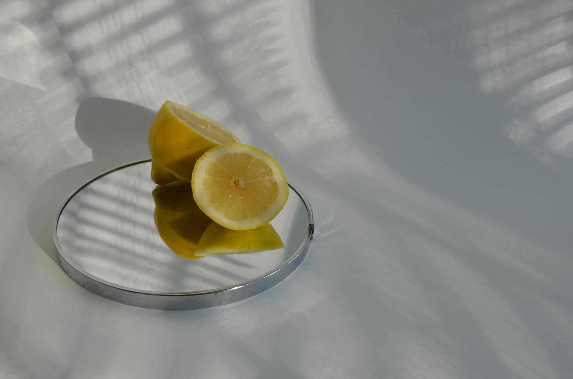 A vibrant blue clitoral vibrator surrounded by flowers and citrus slices on a bright yellow background