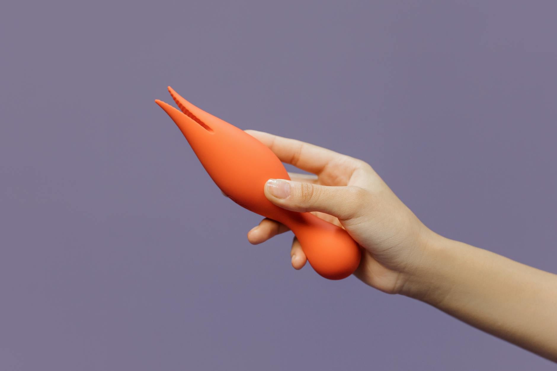 A hand holding a lemon vibrator against a minimalist backdrop, showcasing modern intimacy between partners