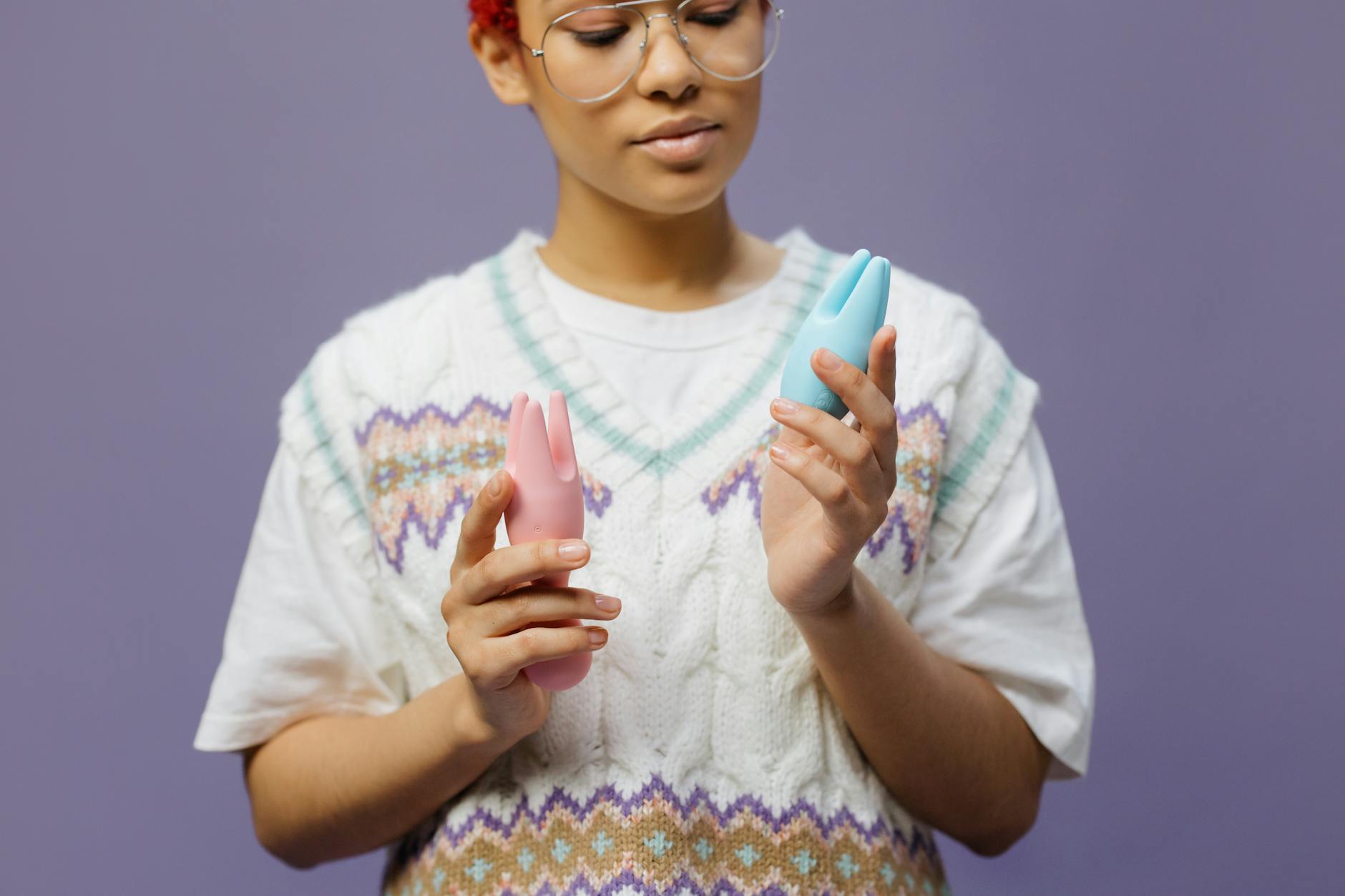 Woman holding a blue silicone clitoral vibrator, representing solo self-pleasure and reconnection with body