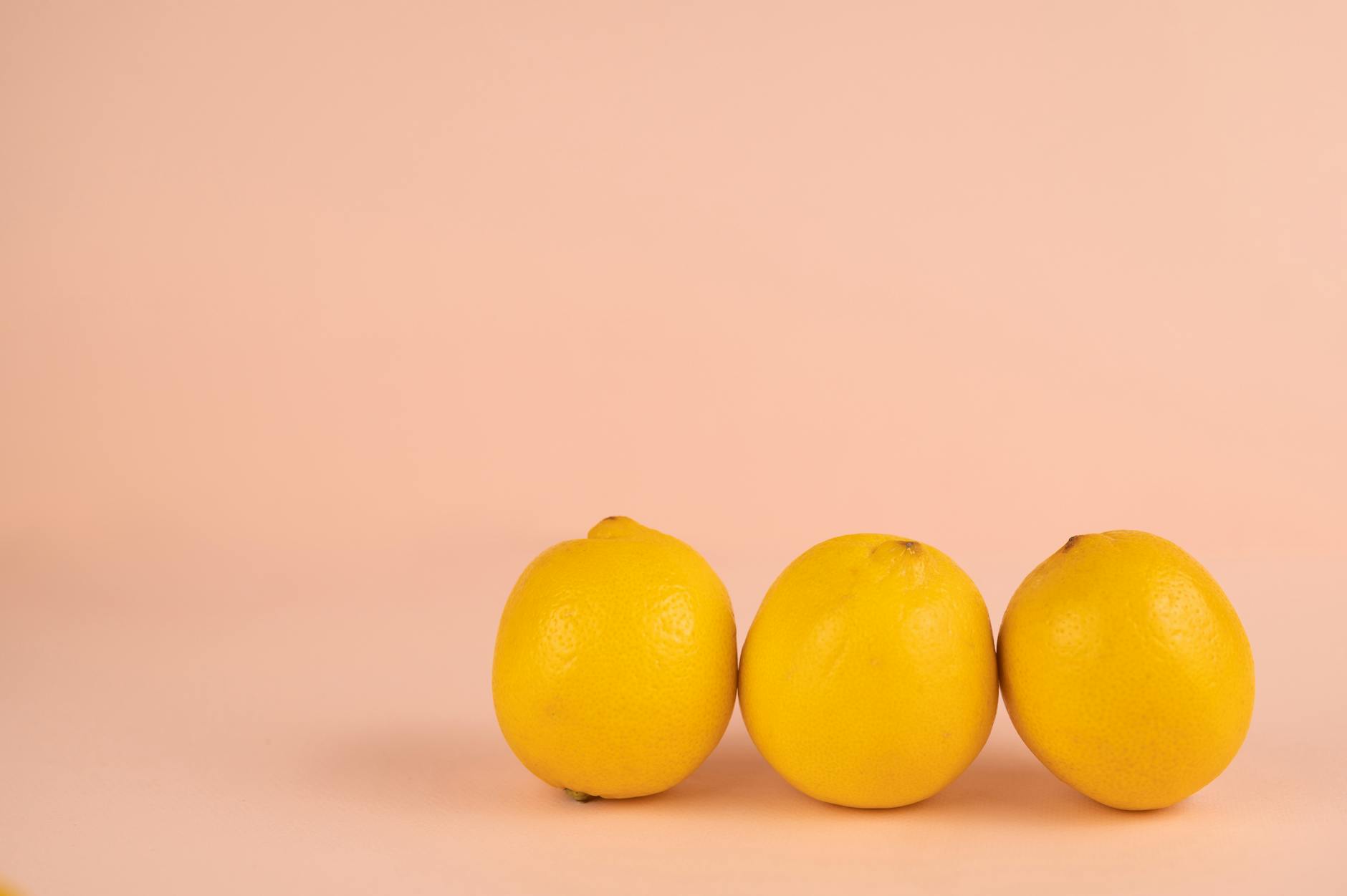 Bright yellow lemons on a soft pastel background, symbolizing fresh approaches to postpartum pleasure